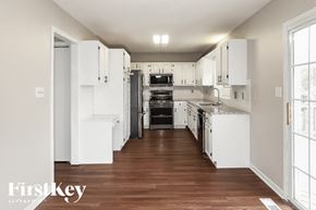 Kansas City house for rent - a white kitchen with white cabinets and a wood floor