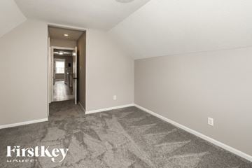 Kansas City house for rent - a spacious living room with carpet and a hallway to the bathroom