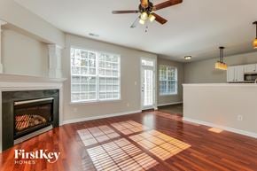 Winston-Salem house for rent - A spacious living room with a fireplace and wooden floors.