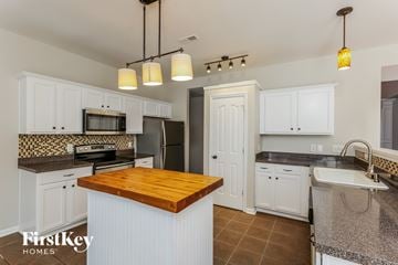 Winston-Salem house for rent - A kitchen with a wooden island in the middle.