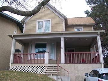 Pullman apartment for rent - A house with a balcony and a tree in front.