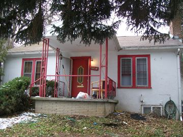 Pullman apartment for rent - A white house with a red door and red railings.