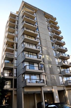 Vancouver apartment for rent - A tall concrete apartment building with balconies on each floor.