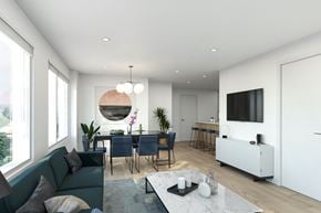 Kelowna apartment for rent - A modern living room with a dark green sofa and a white coffee table.