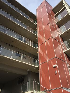 Langford apartment for rent - A tall red building with balconies on the second floor.