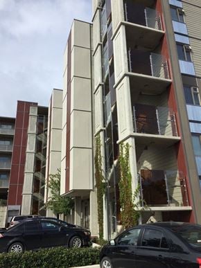 Langford apartment for rent - A black car is parked in front of a tall building.