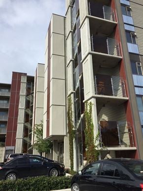 Langford apartment for rent - A black car is parked in front of a tall building.