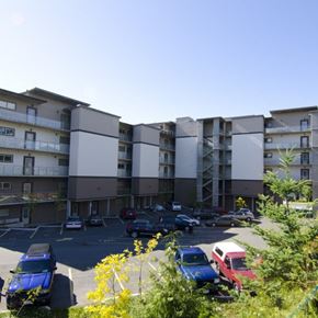 Langford apartment for rent - A parking lot in front of a multi-story apartment building with cars parked in it.