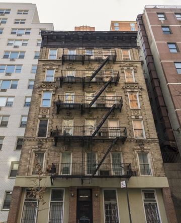 New York apartment for rent - the facade of a brick building with fire escapes