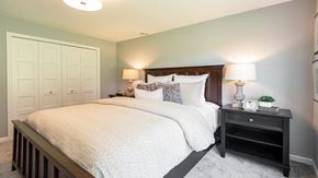 Dayton house for rent - A bedroom with a large bed and a nightstand with a lamp.