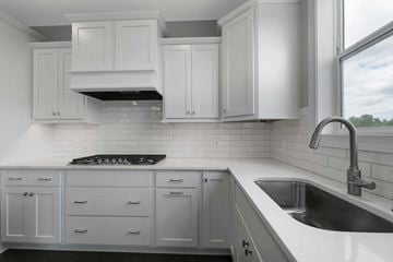 Lake Elmo house for rent - A kitchen with white cabinets and a black stove top.