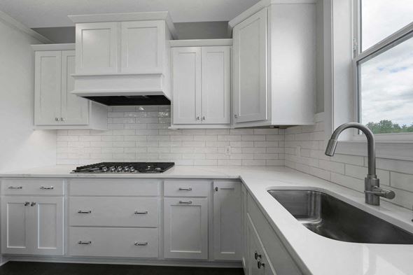 Lake Elmo house for rent - A kitchen with white cabinets and a black stove top.