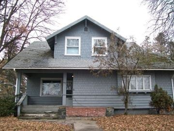 Pullman apartment for rent - A small house with a grey siding and a brick foundation.