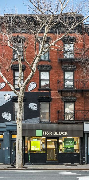 New York apartment for rent - a large brick building with a tree in front of it