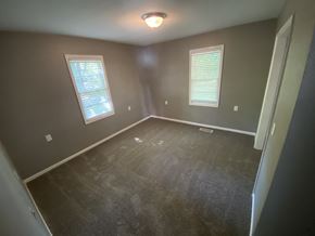 Clinton house for rent - a empty room with a carpet and two windows