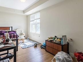 Waterloo apartment for rent - A bedroom with a bed, chair, and a dresser with various items on top.