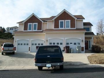 Pullman apartment for rent - A blue station wagon is parked in front of a two-story house.