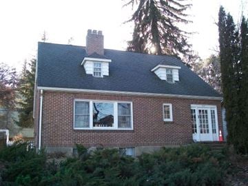 Pullman apartment for rent - A small house with a white door and windows surrounded by trees.