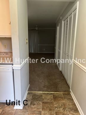 Garner apartment for rent - A hallway with a washer and dryer in the corner.