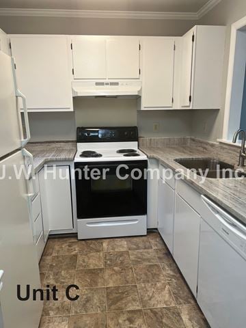 Garner apartment for rent - A kitchen with white cabinets and a black stove top oven.