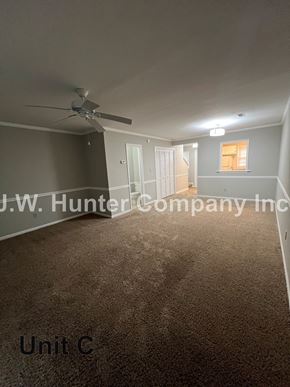 Garner apartment for rent - A room with a carpet floor and a ceiling fan.