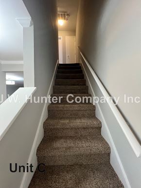 Garner apartment for rent - A staircase with a carpeted runner and white walls.