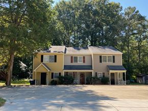 Garner apartment for rent - a yellow house with a large yard and trees