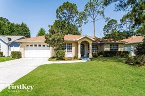 Palm Coast house for rent - a suburban house with a lawn and a white garage door
