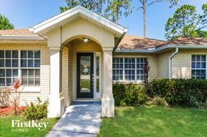 Palm Coast house for rent - a small yellow house with a sidewalk in front of it