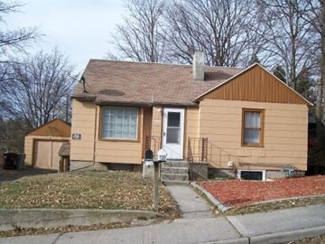 Pullman apartment for rent - a yellow house with a porch and a sidewalk
