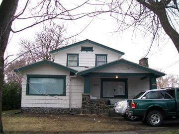 Pullman apartment for rent - A green truck is parked in front of a white house with a green roof.
