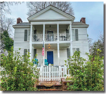 Milledgeville apartment for rent - A white house with a blue door and a flag on the porch.