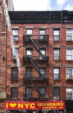 New York apartment for rent - a red brick building with fire escapes on the side of it