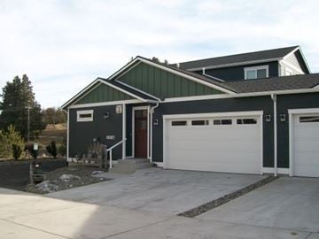 Pullman apartment for rent - A two-story house with a garage door and a red door.
