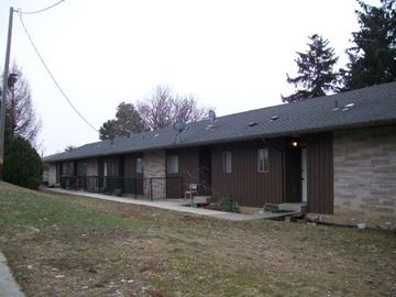 Pullman apartment for rent - A brown house with a grey roof and a small front yard.
