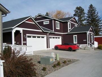 Pullman apartment for rent - A red car is parked in front of a two-story house.