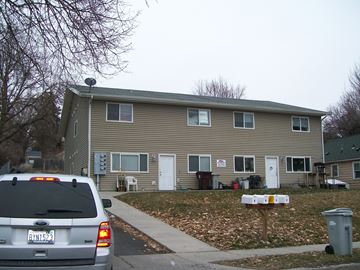 Pullman apartment for rent - A grey two story house with a silver van parked in front.
