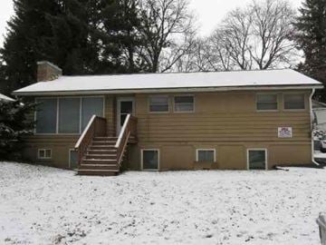 Pullman apartment for rent - A house with a snow-covered roof and a sign on the front door.