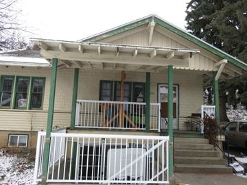 Pullman apartment for rent - a house with a porch with green posts and a white fence
