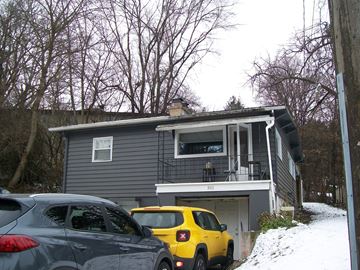 Pullman apartment for rent - A grey house with a yellow car parked in front.