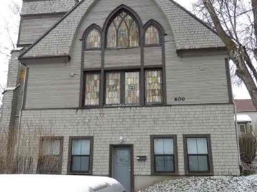 Pullman apartment for rent - A grey house with a large arched window and a door.