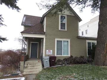Pullman apartment for rent - a yellow house with a sign on the front of it