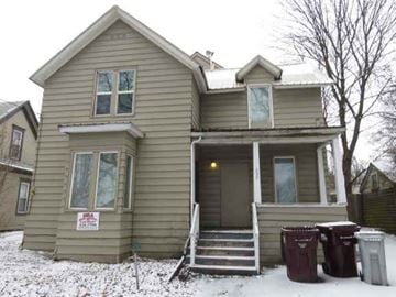 Pullman apartment for rent - a green house with trash cans in the snow