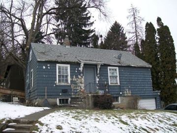 Pullman apartment for rent - A blue house with a white door and windows is surrounded by snow.