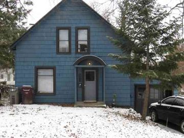 Pullman apartment for rent - A blue house with a black car parked in front.