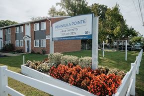 Hampton apartment for rent - a building with a sign in front of a bed of flowers