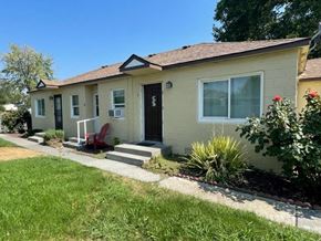 Kennewick apartment for rent - a tan house with a red chair in front of it