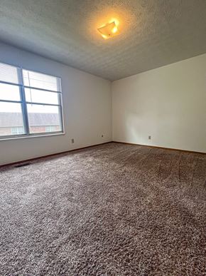 Pickerington apartment for rent - an empty living room with carpet and a window