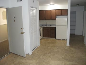 Columbus apartment for rent - an empty kitchen with white appliances and wooden cabinets