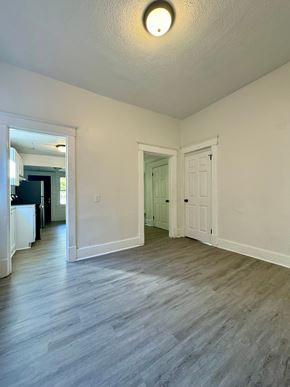 Louisville house for rent - an empty living room and hallway with white walls and wood floors